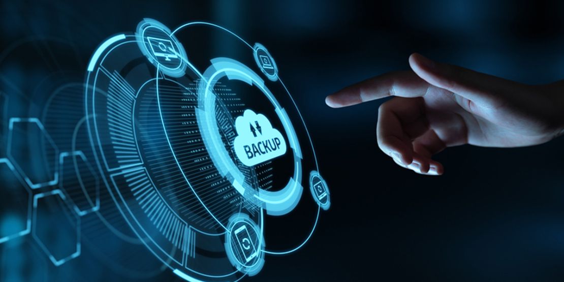 A hand points at a digital interface with a cloud backup icon and holographic technological graphics.