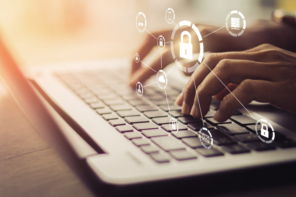 Hands typing on a laptop keyboard with digital security lock icons overlaid, representing cyber security and data protection.